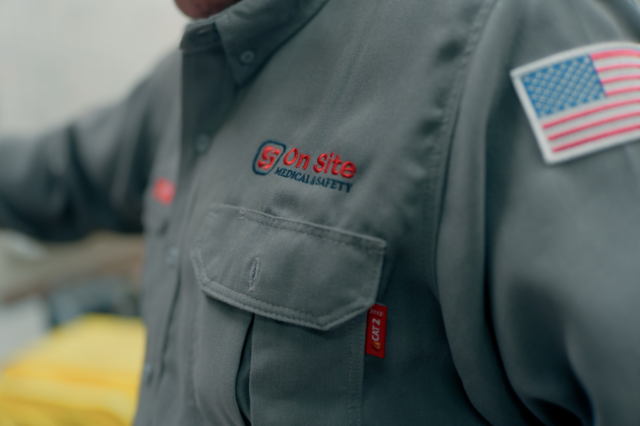 On Site Medical & Safety — the primary logo embroidered on a work shirt